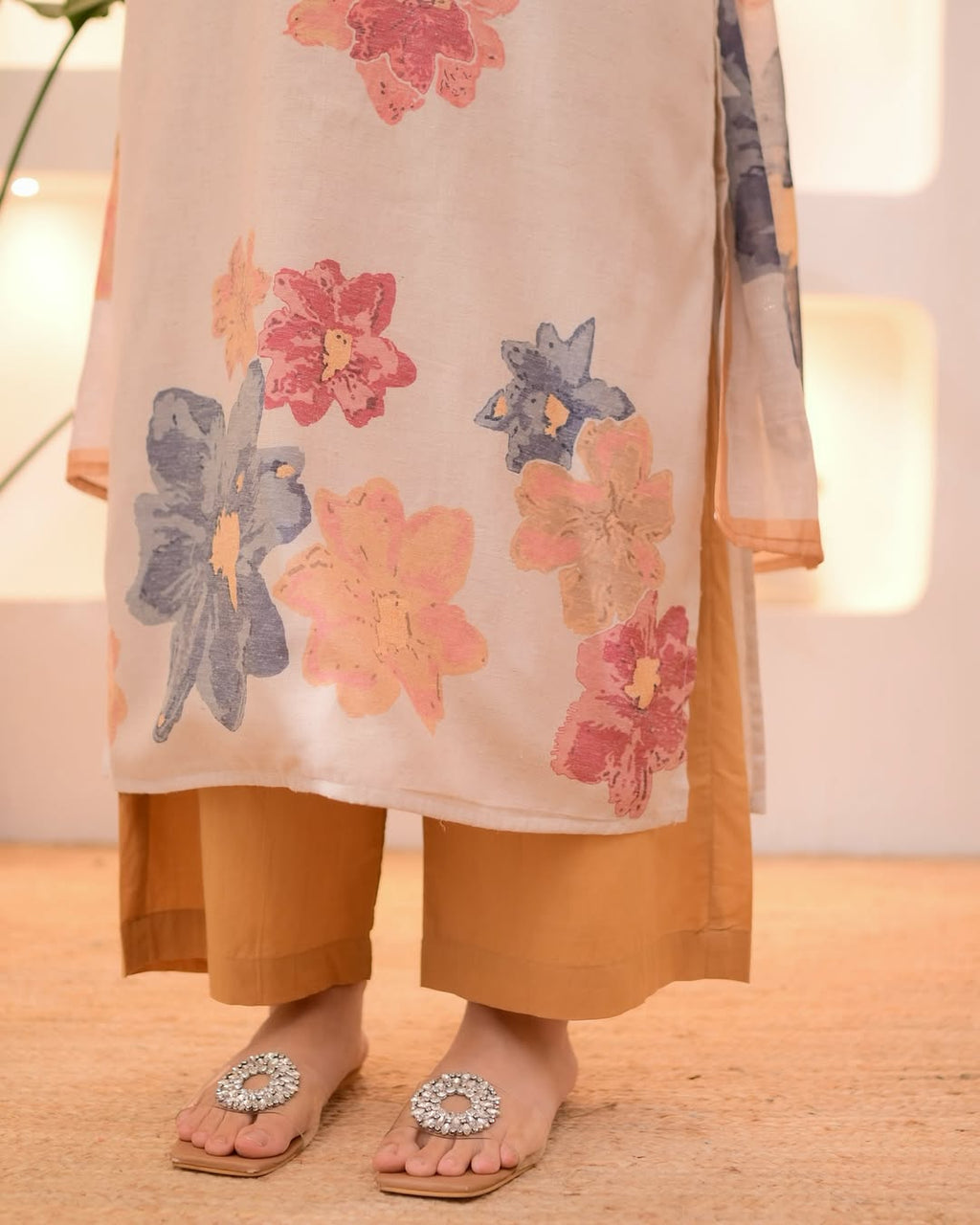 This outfit appears to be a cotton salwar kameez set, featuring a light pink kurta with a floral print.