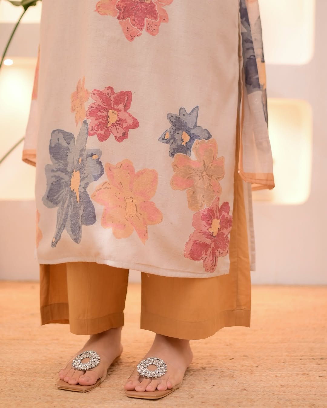This outfit appears to be a cotton salwar kameez set, featuring a light pink kurta with a floral print.