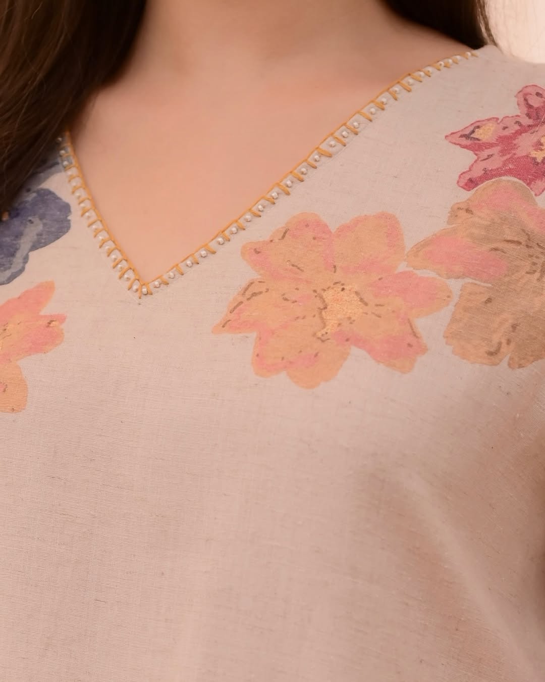 This outfit appears to be a cotton salwar kameez set, featuring a light pink kurta with a floral print.